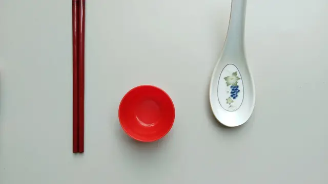 흰 배경에 놓인 젓가락과 아시아식 숟가락
